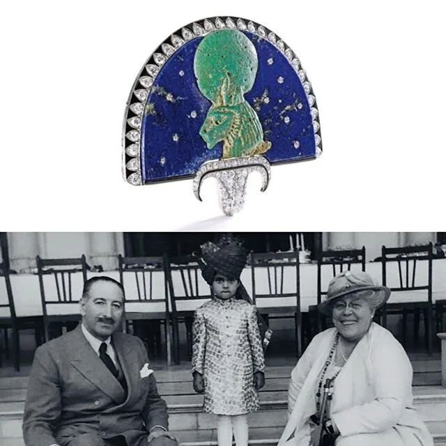 Emerald elephant and lapis lazuli brooch above a vintage photo of three people.