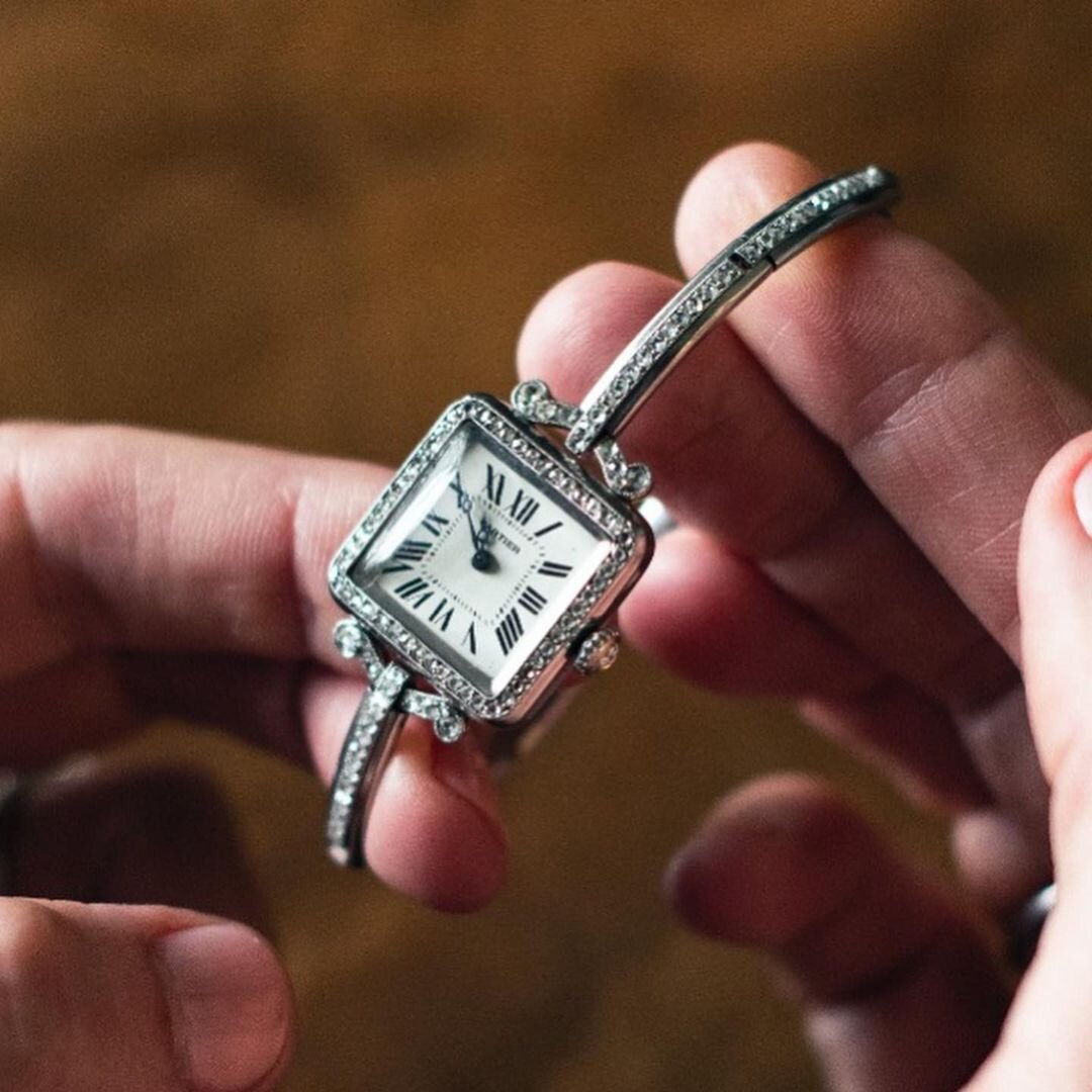 Vintage Cartier square diamond wristwatch with Roman numerals and a diamond bangle bracelet.