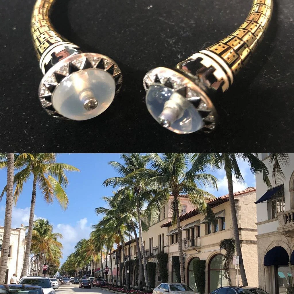 Vintage gold and enamel bracelet ends with moonstone cabochons, above a luxury shopping street.