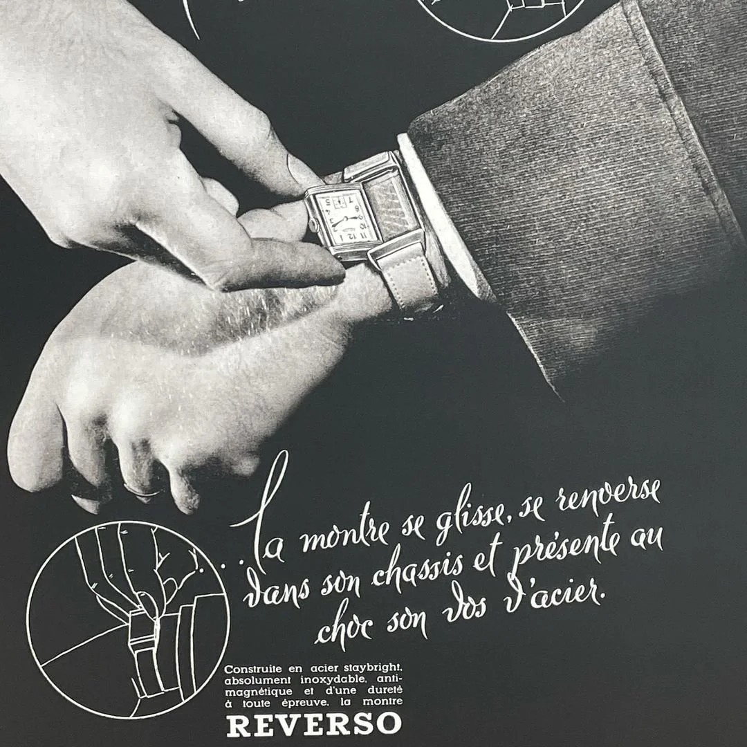 Vintage black and white ad showing a man's hands adjusting a rectangular Reverso watch.