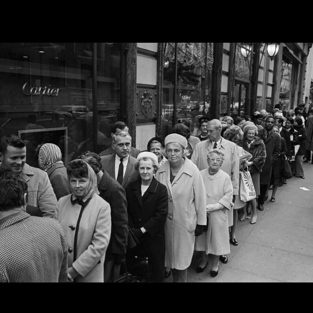 Black and white long queue of people outside a Cartier store, mid-century.